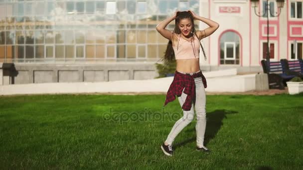 Junge Hipsterfrau mit Ängsten, die an einem strahlend sonnigen Sommertag in einem Park an Wagenrädern dreht. Zeitlupenschuss — Stockvideo