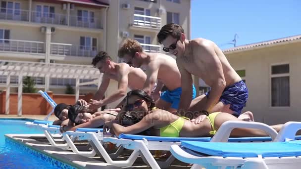 Жінки отримують масаж від своїх хлопців у прекрасній віллі біля басейну. Постріл уповільнення . — стокове відео