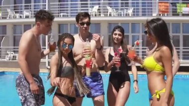 Kokteyler içme ve eğlenmek Havuz Villa mutlu genç neşeli arkadaşlar bikini ve mayo müzik için bekleyen ve dans etmeye başladı. Yaz aylarında havuz partisi. Slowmotion atış