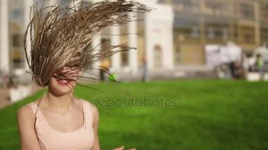 Genç güzel kız dreads bir parkta dans ile. Müzik ve güneşli bir gün boyunca dans kot pantolon güzel bir kadın. Slowmotion atış.