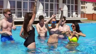 Dans ve sıcak yaz günlerinde suya serinlemek havuzda eğleniyor mutlu genç neşeli arkadaşları. Yaz aylarında havuz partisi. Slowmotion atış.