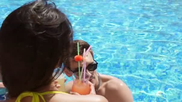 Mladý dospělý pár flirtování a mluví v bazénu. Letní bazénová party. Slowmotion shot — Stock video