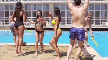 Dans ve having fun havuzda mutlu genç neşeli arkadaşları. Yaz aylarında havuz partisi. Slowmotion atış
