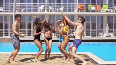Dans ve having fun havuzda mutlu genç neşeli arkadaşları. Yaz aylarında havuz su silahlarla parti. Slowmotion atış