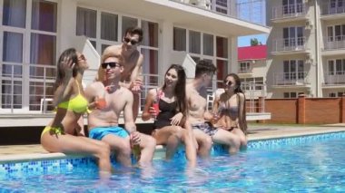 Mutlu grup kokteyler ile takılmak ve yaz aylarında havuz kenarında sohbet genç arkadaşlar. Havuz partisi. Slowmotion atış
