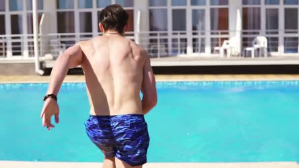 다시 실행 하 고 점프 수영장 수영 반바지에 운동 젊은이의 보기. Slowmotion 샷. — 비디오