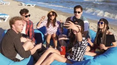 Bir video veya alarak selfie easychairs üzerinde sahilde oturup, gitar çalmak ve bir yaz akşamı şarkı arkadaş grubunun kayıt genç hippi kız. Slowmotion atış