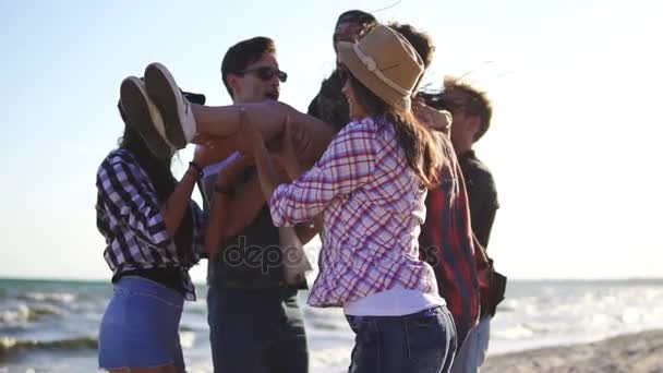 Grande grupo de jovens levantando sua amiga no ar e atirando-a para cima em mãos levantadas. Tiro em câmara lenta — Vídeo de Stock