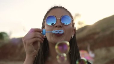Neşeyle sabun köpüğü sahilde akşamları yapma dreads ile genç kadın hippi. Slowmotion atış