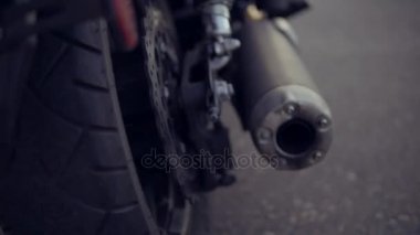 Motosiklet koltukta oturan uzun saçlı kadın bir bisikletçinin arkadan görünüm. Genç kıvırcık kadının bacağındaki siyah çizmeler vites deitirme Vites ile helikopter üzerinde kapat