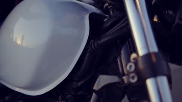 Uma motociclista bonita com calções a começar a mota. Close up de jovem sexy curly mulher em óculos de sol no helicóptero — Vídeo de Stock