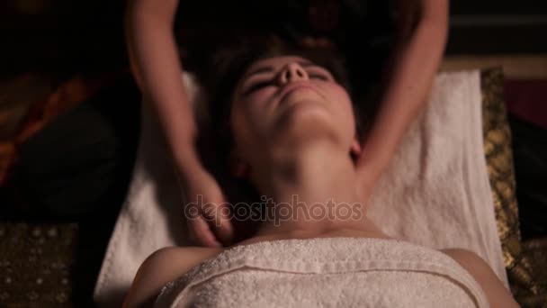 Jonge vrouw met haar ogen gesloten met Thaise massage van haar nek en schouders in spa door een vrouwelijke massagist. Gezondheidszorg en spa. Tikje schot — Stockvideo