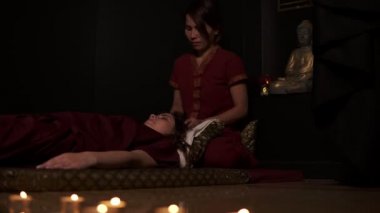 İki Tay masaj terapistleri, baş ve ayaklar kadın kanepede spa Oda için Tay masajı yapıyor. Ağır çekim vurdu