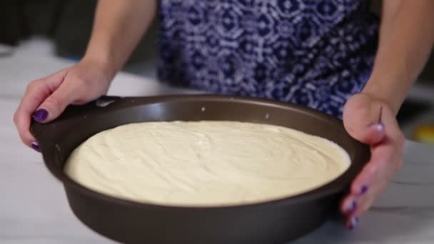 Крупный план женских рук, трясущих сковороду с белым сливочным сыром, разбросанным по основанию печенья. Процесс приготовления сырного торта. Домашняя пекарня. Слоумоушн — стоковое видео