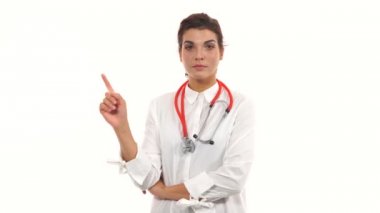 Genç kadın doktor, kötü bir alışkanlık hakkında uyarı Görüntüleyici, parmağını sallayarak. Beyaz arka plan üzerinde izole stetoskop ve laboratuvar montlu bir kadın cerrah yakın çekim