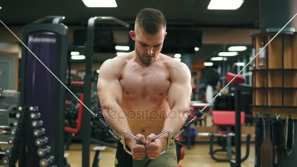 Shirtless handsome athletic man doing pectorals on the crossover trainer in the gym. Shot in 4k — Stock Video