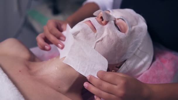 Closeup άποψη της επαγγελματικής cosmetologist apllying ειδική μάσκα για γυναικείο πρόσωπο και το λαιμό. Επαγγελματική carboxytherapy για νεαρή γυναίκα στο σαλόνι σπα — Αρχείο Βίντεο