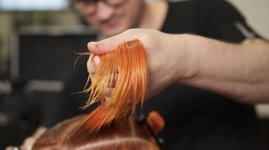 Hair coloring. Dark-haired young woman colouring her hair in a ... Hair coloring. Dark-haired young woman colouring her hair in a ...