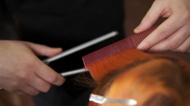 Kızıl saçlı womas saç saç salonda bir hairstraightener kullanarak bir profesyonel saç stilist tarafından doğruldu closeup görünümü. Slowmotion atış