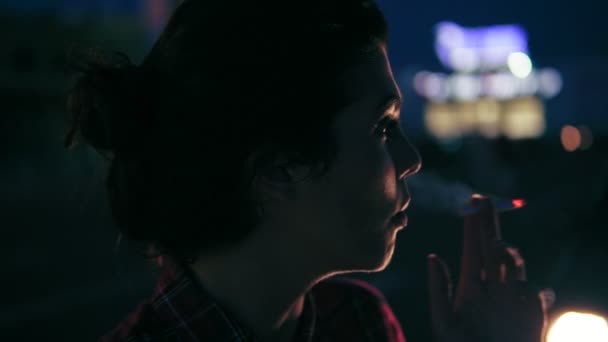 Düşünceli genç kadın gece şehirde bir sigara içiyor. Portre. Slowmotion atış — Stok video