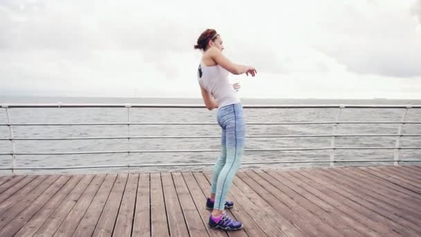 後屈をして、海のビーチでストレッチ運動若い女性。スローモーション撮影 — ストック動画