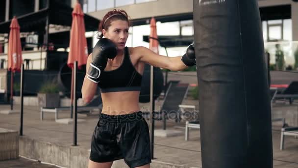Привлекательная спортсменка-боксер в перчатках, тренирующаяся с сумкой. Тренировка снаружи. Обучение боксеров. Понятие самозащиты. Слоумоушн — стоковое видео