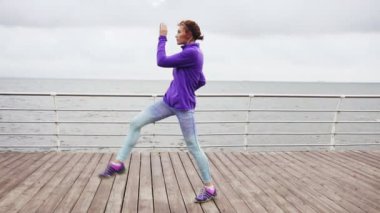 Egzersiz, bacaklar tekme ve okyanus plaj sabah erken uzanan genç kadın. Slowmotion atış