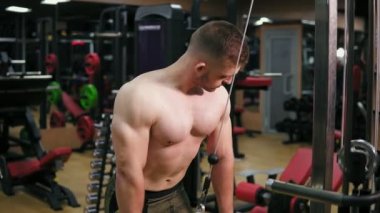 Gömleksiz çekici adam eğitim triceps crossover spor salonunda kullanarak. Kas vücut, closeup görünümü. 4 k'dan fazla vurdu