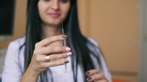 Vista de cerca de una jeringa que se está revisando antes de la inyección. Doctora morena joven preparando una jeringa para inyección. Disparo en cámara lenta — Vídeos de Stock