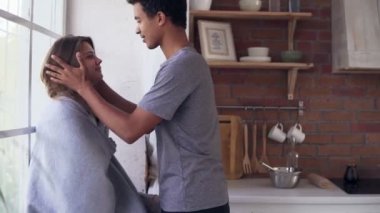 Yakışıklı Afrika dostum şefkatle alın birlikte mutfakta duran kız öpüşme. Genç kadın battaniye ile örtülü. Sevgi genç çift evde öpüşme