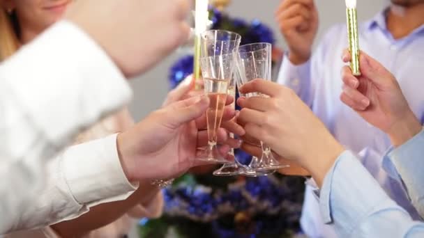 Grupo multiétnico de trabalhadores de escritório felizes batendo copos com vinho espumante enquanto segurando luzes de Bengala e vestindo chapéus de Natal celebrando o Natal e Ano Novo. Tiro em câmara lenta — Vídeo de Stock