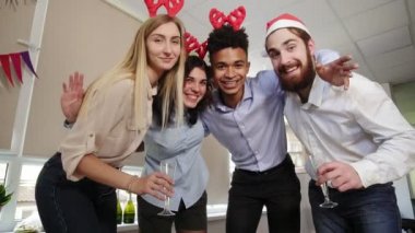 Noel Baba şapkaları mutlu iş insanlar kamera seyir ve süre kutlama yeni yıl ofiste gülümseyen selfie yapıyor. Slowmotion atış