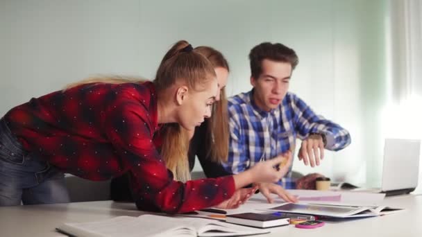 Üç Kişilik modern bir ofiste toplantı yaratıcı iş ekip. Bir kadın onun kalem kağıt işaret eden bir şey göstereceğim. masada otururken tartışırken iş fikirleri 2 kadın ve 1 erkek — Stok video