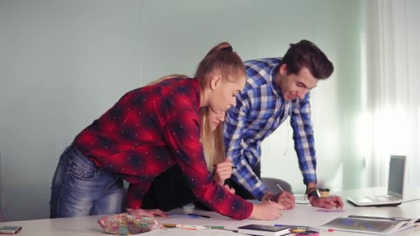 Reunião da equipe de designer de interiores no escritório criativo. Jovens hipsters fazendo esboços em pé à mesa e discutindo seu novo projeto. Tiro em câmara lenta — Vídeo de Stock