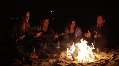 Akşam şenlik ateşi ile gençlerin gece geç saatlerde piknik. Şarkılar ve gitar çalmak, söz ve having fun birlikte neşeli arkadaşları