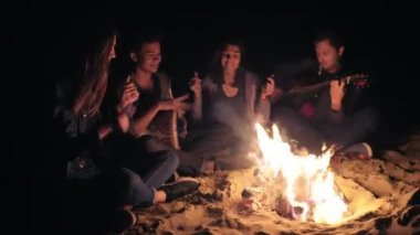 İki genç kadın ve iki adam tarafından şenlik geç gece ve şarkıları söyleyerek, oturup iskambil gitar ve perküsyon