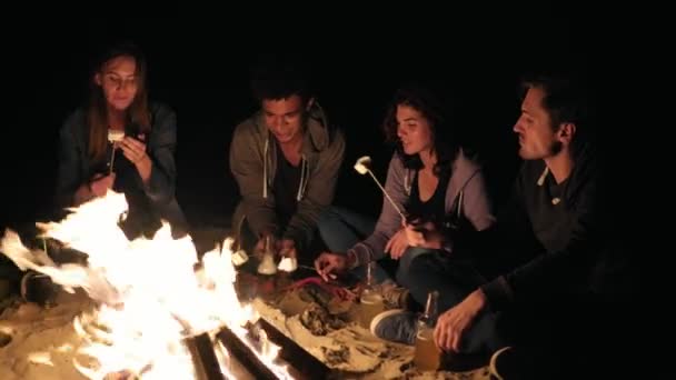 Praia festa tarde da noite com fogueira e assar mellows pântano com amigos — Vídeo de Stock