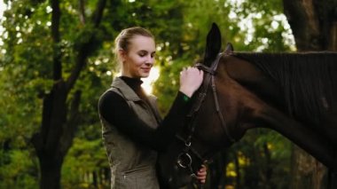 Gülümseyen kadın kahverengi at kafası güneşli gün boyunca ormanda dururken palming