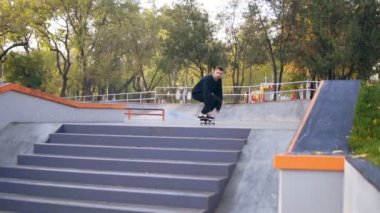 Merdivenlerden aşağı atlamayı genç hipster kaykaycı. Skatepark Ollie hüner. Slowmotion atış