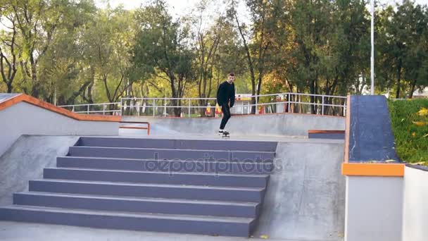 Hipster skater jumping over the stairs in skate park. Slowmotion shot — Stock Video