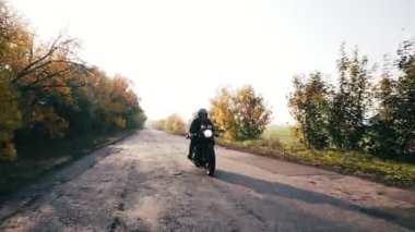 Ön görünüm: bir ülke yolda motosiklet binme kask içinde adam