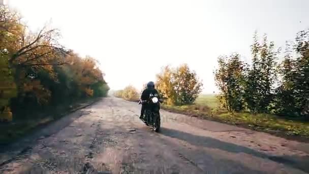 Front view: Man in helmet riding motorcycle on a country road — Stock Video