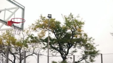 Kadar atlama ve onun el tarafından bir basketbol halka isabet genç Afrika çalar. Slowmotion atış