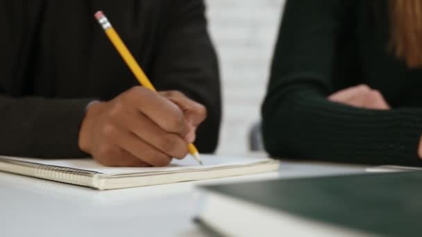 Vista de cerca de diversos estudiantes multiétnicos que escriben un examen en la escuela o la universidad. Prueba en la escuela. Disparo en cámara lenta — Vídeo de stock