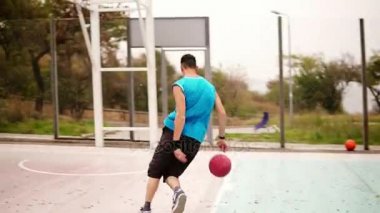 Genç bir kadeh izleme bir top ile çalışan ve bir top sepete başarıyla atma dostum. Basketbol oyunu. Slowmotion atış