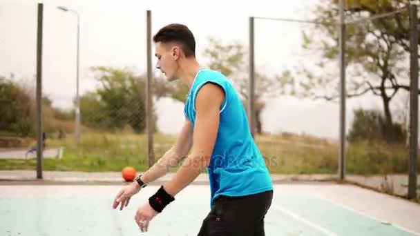 Hombre lanzando pelota de baloncesto en la cancha en el parque, tiro en cámara lenta — Vídeos de Stock