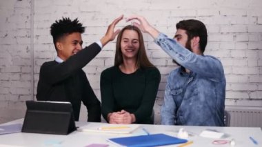 Çok etnik gruptan oluşan iş modern ofis masada oturan veren yüksek beş takım. Slowmotion atış