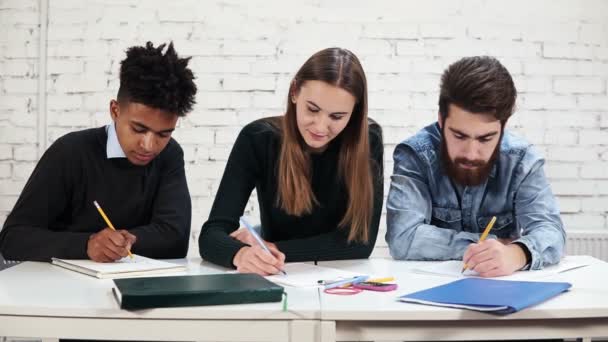 Jovens estudantes multi-étnicos diversos escrevendo um exame na escola ou universidade. Teste na escola. Tiro em câmara lenta — Vídeo de Stock