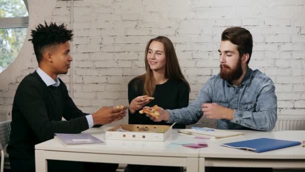 Obchodní tým mladých lidí těší pizza spolu v kanceláři, Millenials skupiny mluvící s fun sdílení oběd v útulné kanceláři, dobré vztahy v práci, Donáška jídel a catering — Stock video