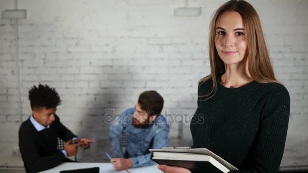 Portret szczęśliwy senior interesu w biurze z jej kolegów posiadających folder z dokumentów i patrząc na kamery. Jej colleques mężczyzna rozmowa na tle — Wideo stockowe